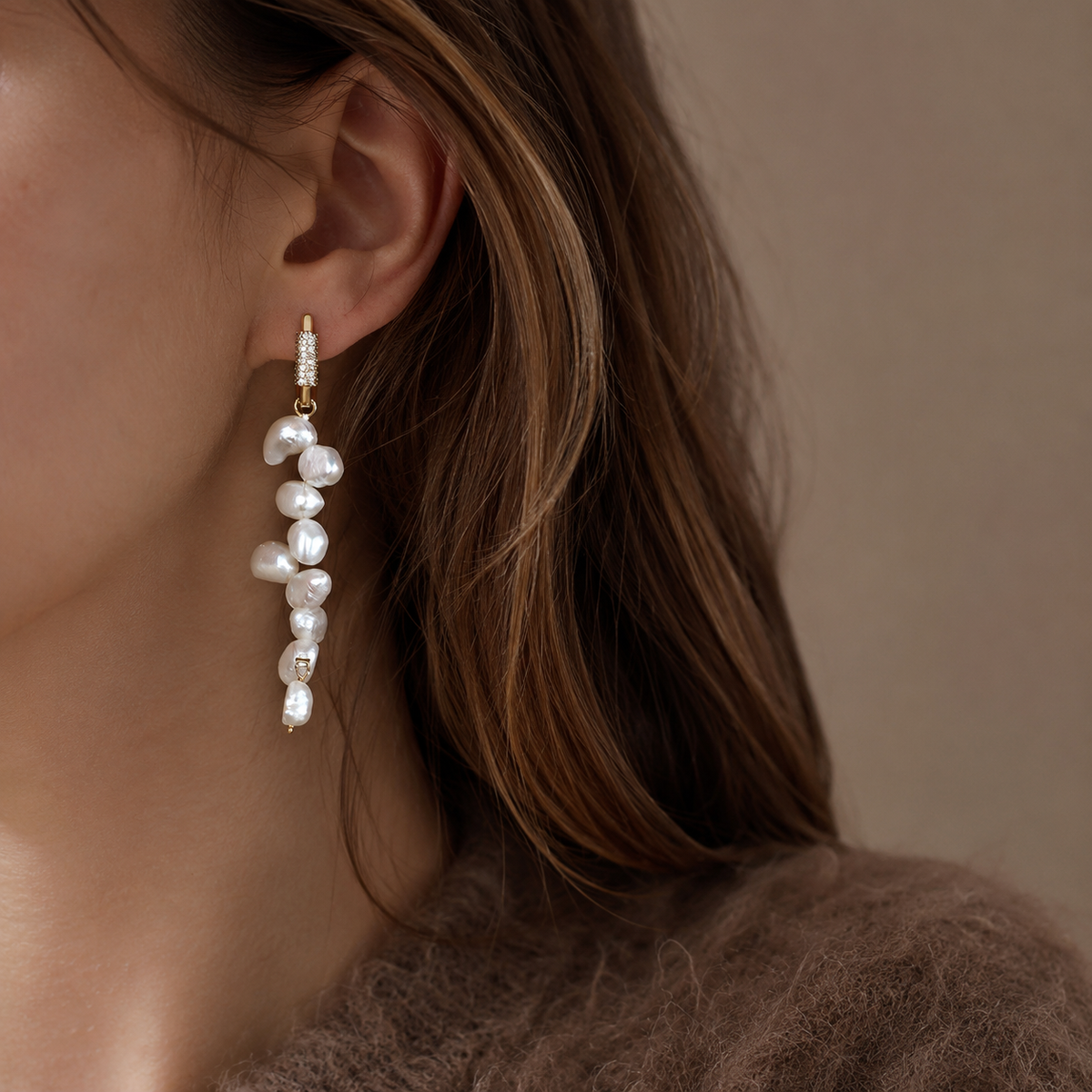 Side view of 14K gold huggie hoop and baroque freshwater pearl drop earring