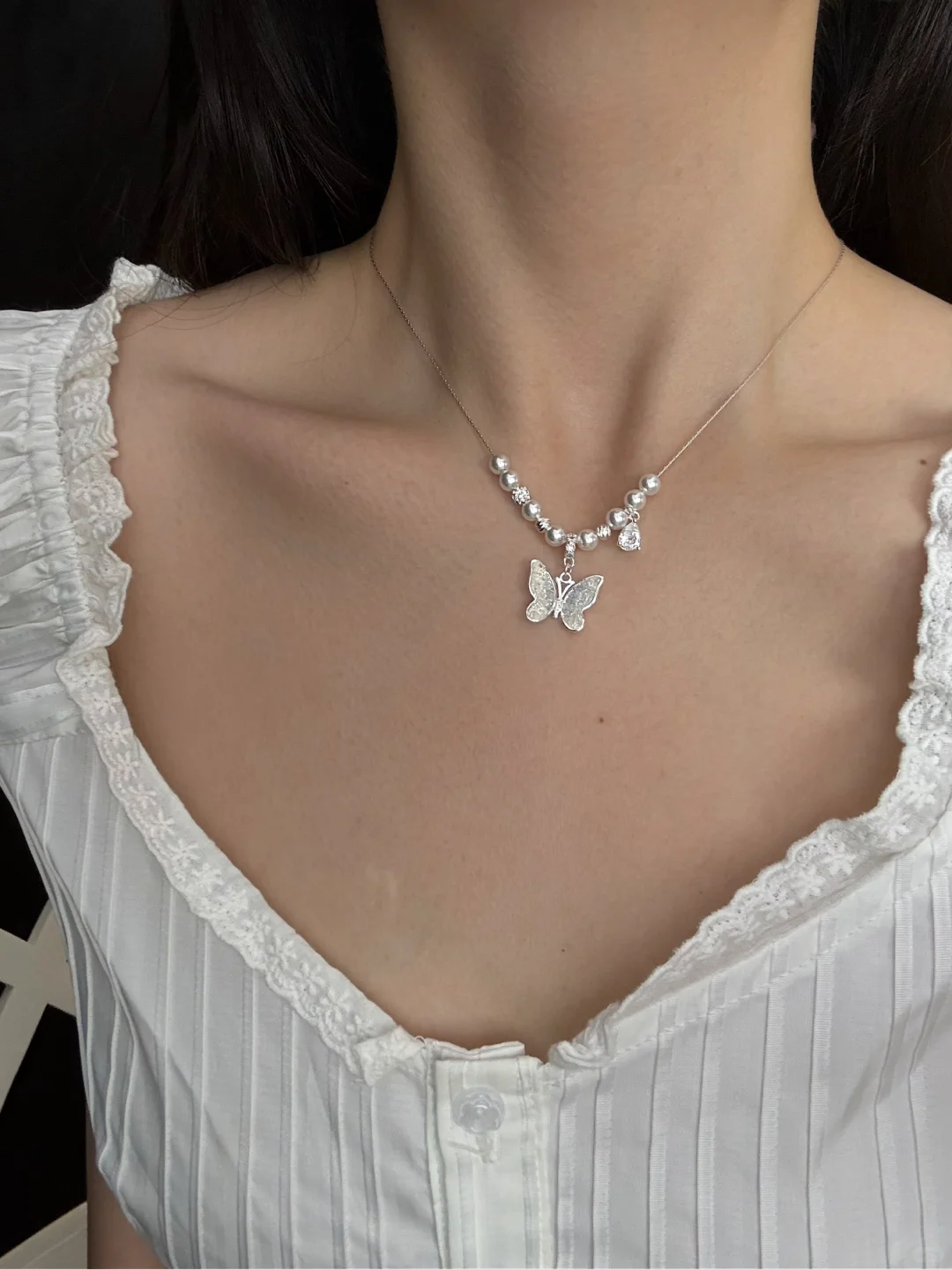 Styled view of butterfly pendant high-lustre freshwater pearl necklace for weddings