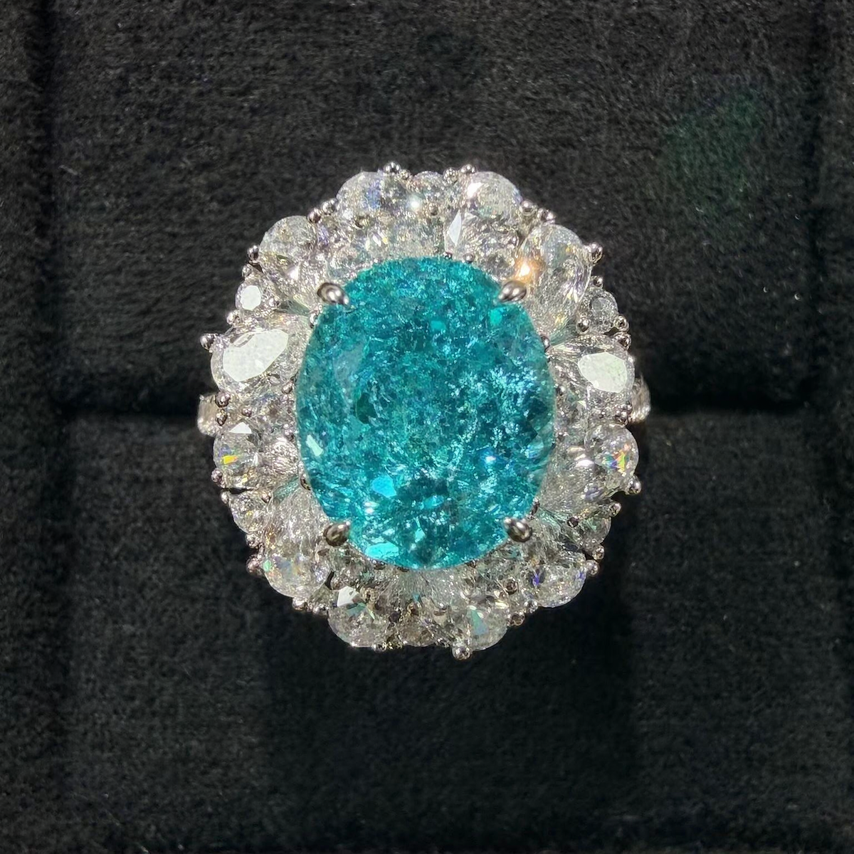 Front view of large oval lab-grown Paraiba gemstone halo ring for statement proposals