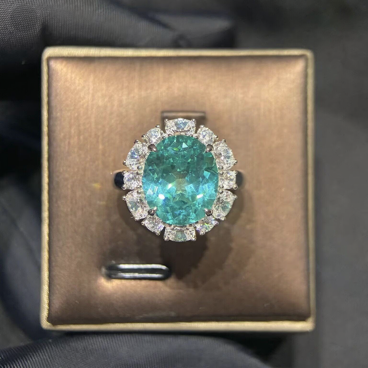 Front view of large oval lab-grown Paraiba gemstone halo ring for statement proposals
