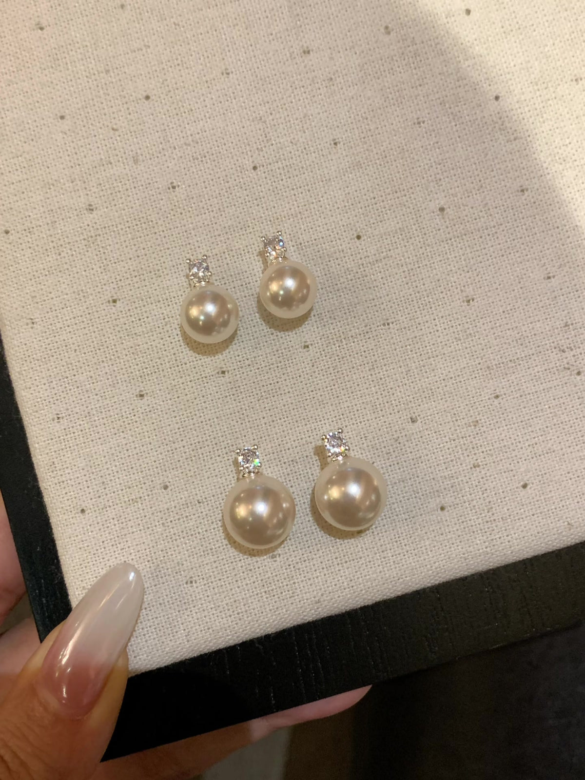 Styled view of halo drop high-lustre freshwater pearl earrings for wedding guest looks