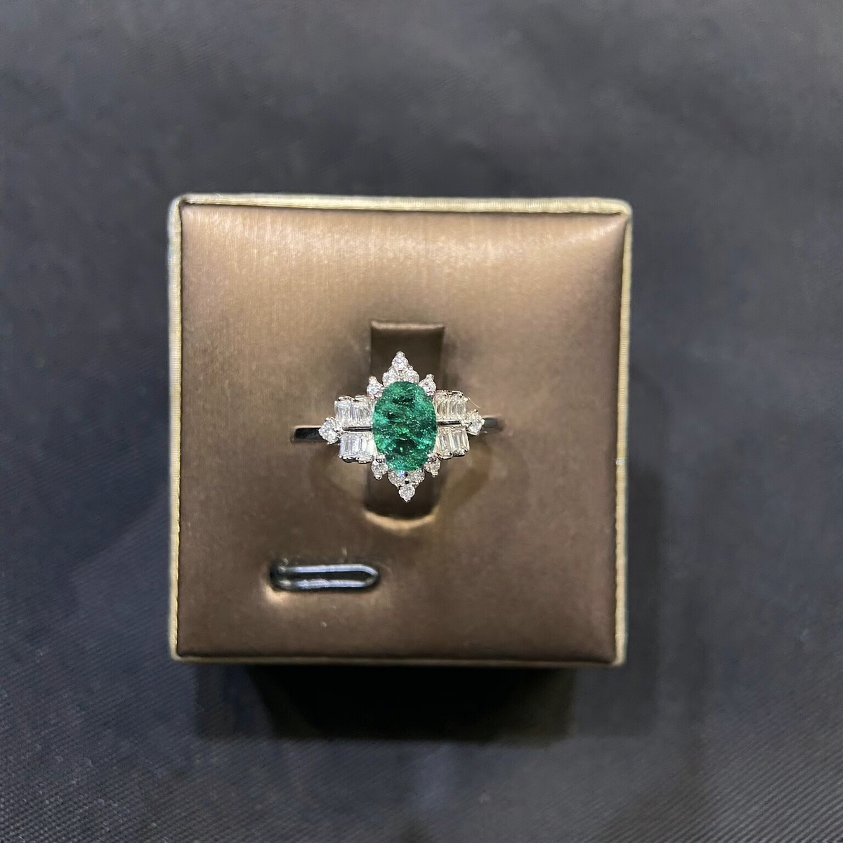 Front view of oval lab-grown emerald side-stone ring for engagement moments