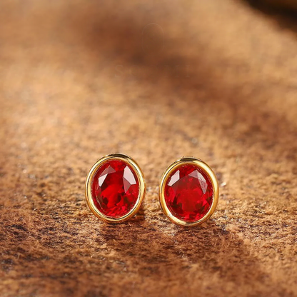 Styled view of oval lab-grown ruby bezel stud earrings in 16K gold for everyday elegance