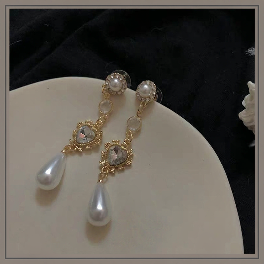 Styled view of long drop high-lustre freshwater pearl earrings for wedding guest looks
