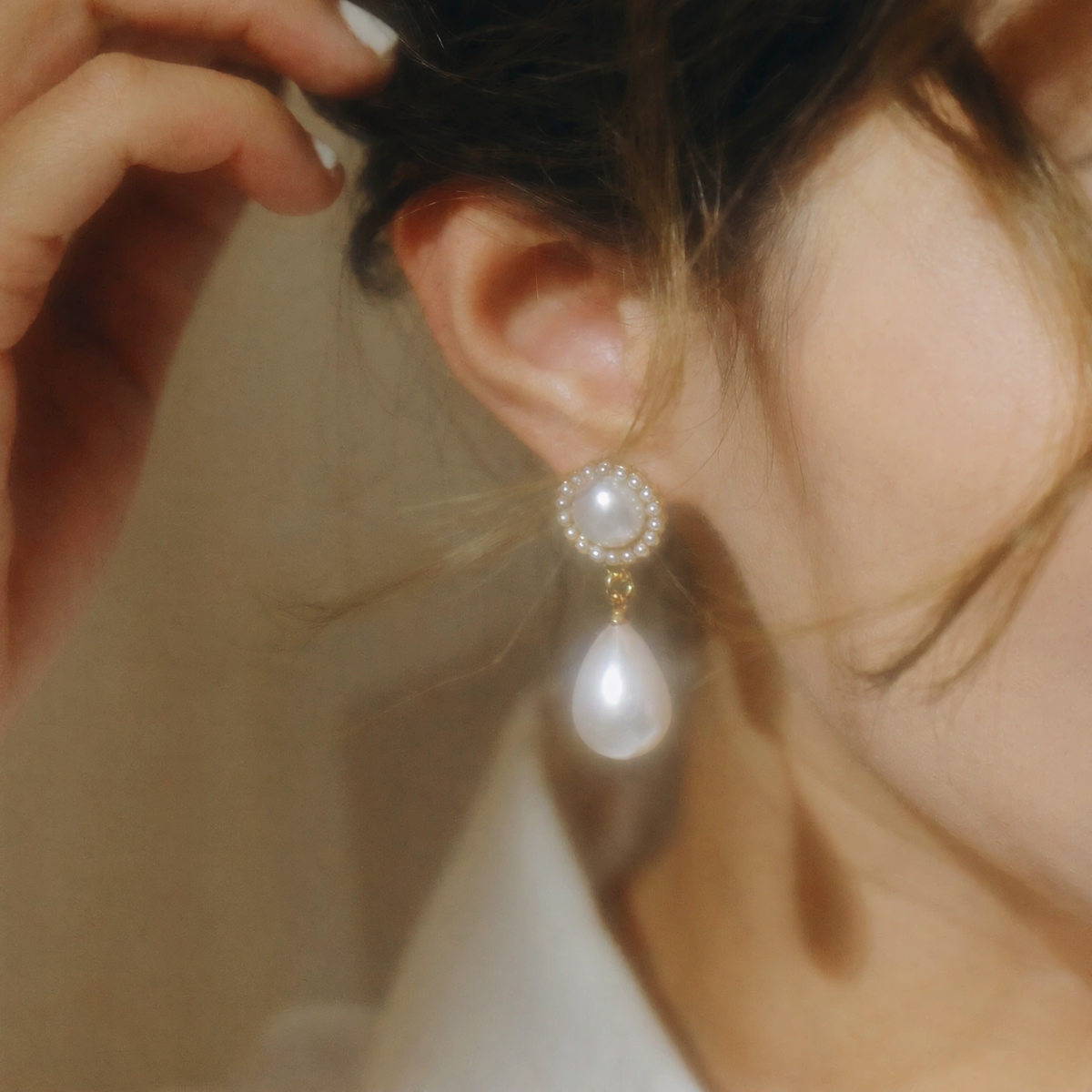 Side view of teardrop halo high-lustre freshwater pearl earrings for wedding guest looks