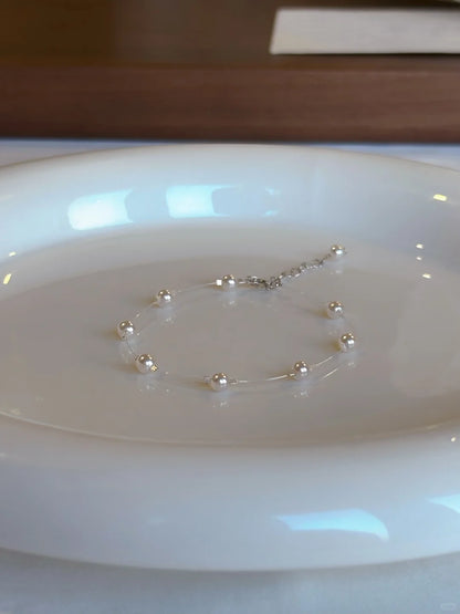 Close-up of delicate station high-lustre freshwater pearl bracelet for bridal styling