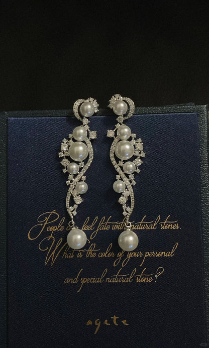 Styled view of ornate grey drop high-lustre freshwater pearl earrings for wedding guest looks