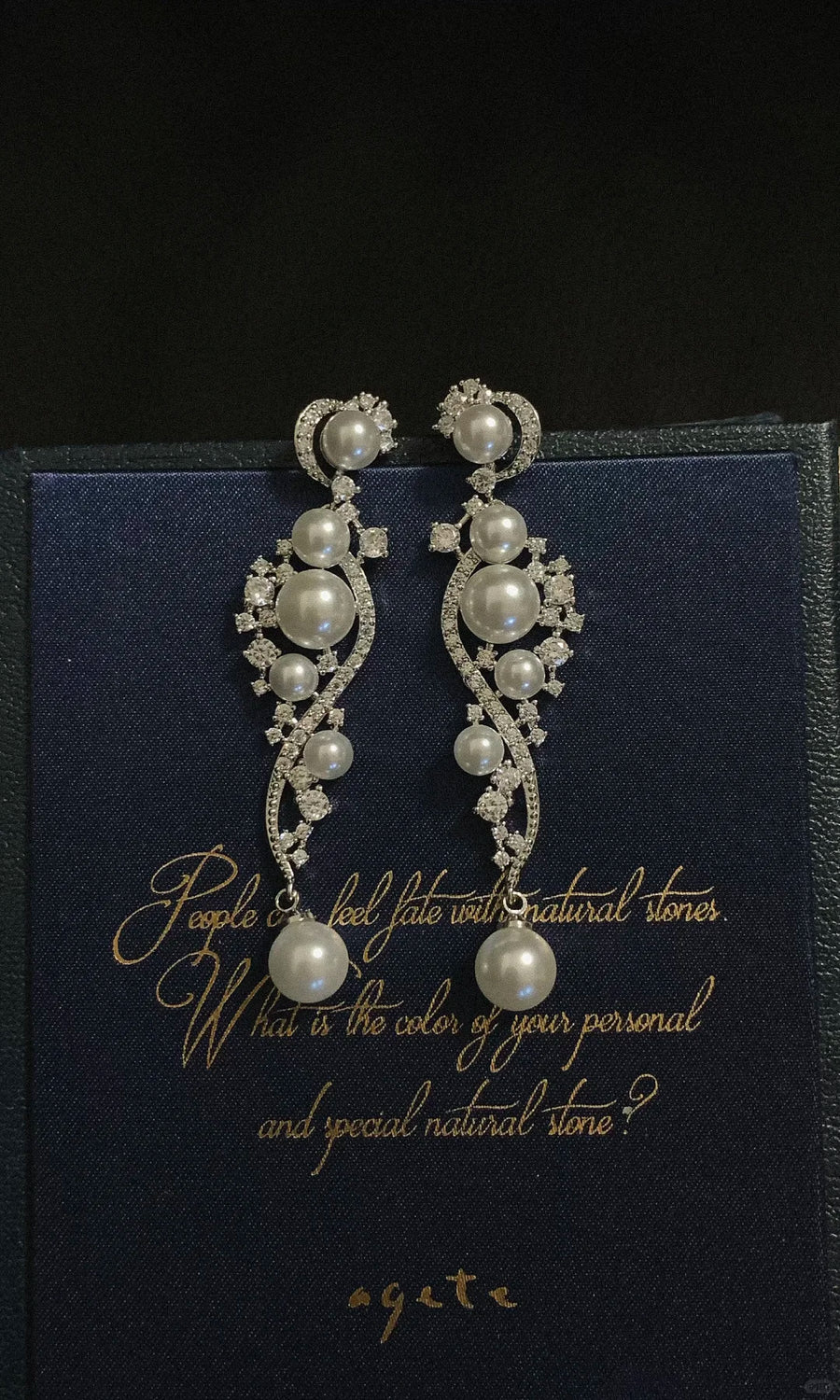 Styled view of ornate grey drop high-lustre freshwater pearl earrings for wedding guest looks