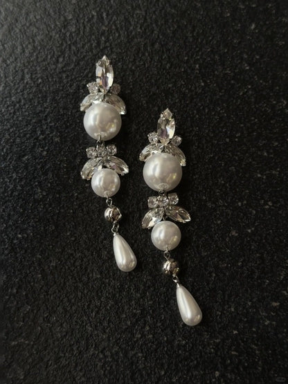 Styled view of long drop high-lustre freshwater pearl earrings for wedding guest looks