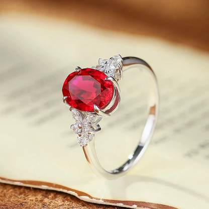 Close-up of oval lab-grown ruby three-stone ring in 16K gold for engagement moments