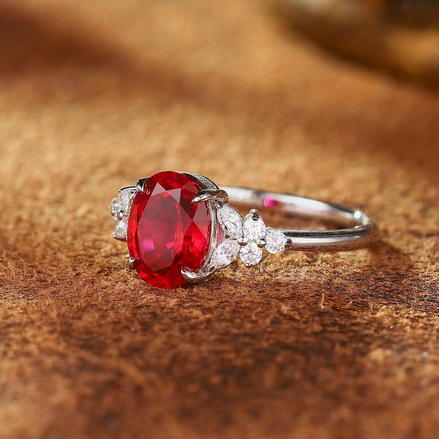 Styled view of oval lab-grown ruby three-stone ring in 16K gold for engagement moments