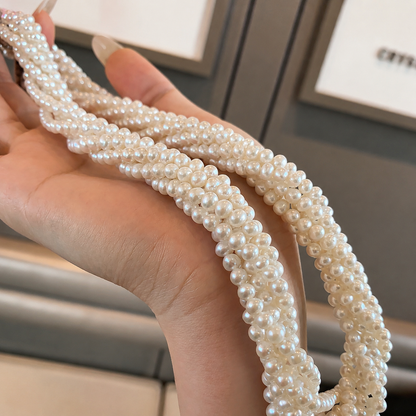 Multiple strands of luminous 4–6mm freshwater pearls held in the hand