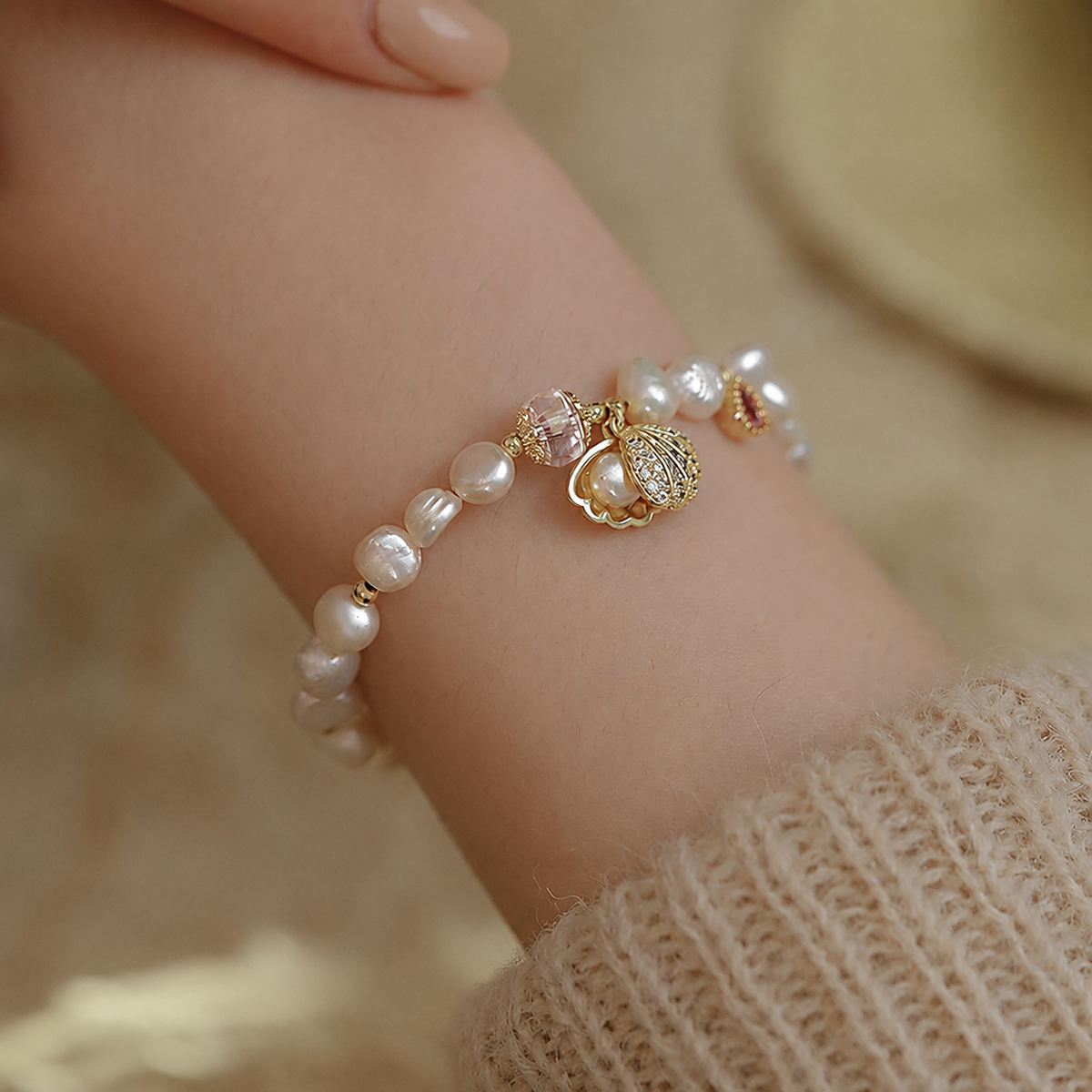 Adjustable freshwater pearl charm bracelet worn on the wrist