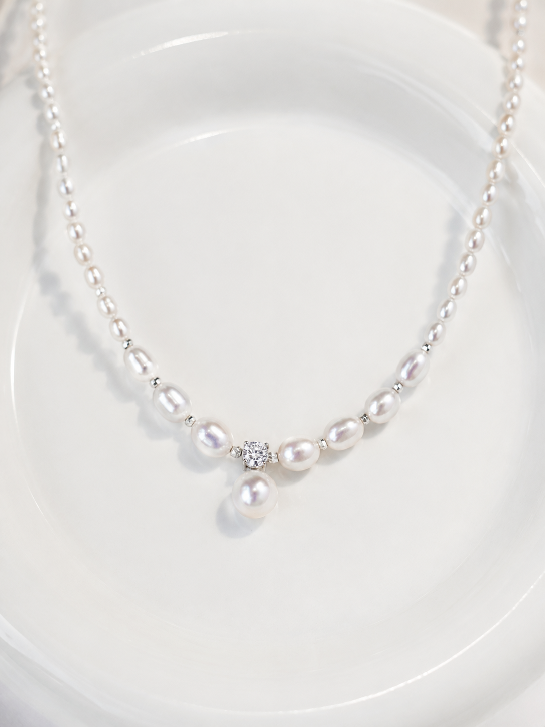 Mira freshwater pearl pendant necklace with silver spacers on a white background