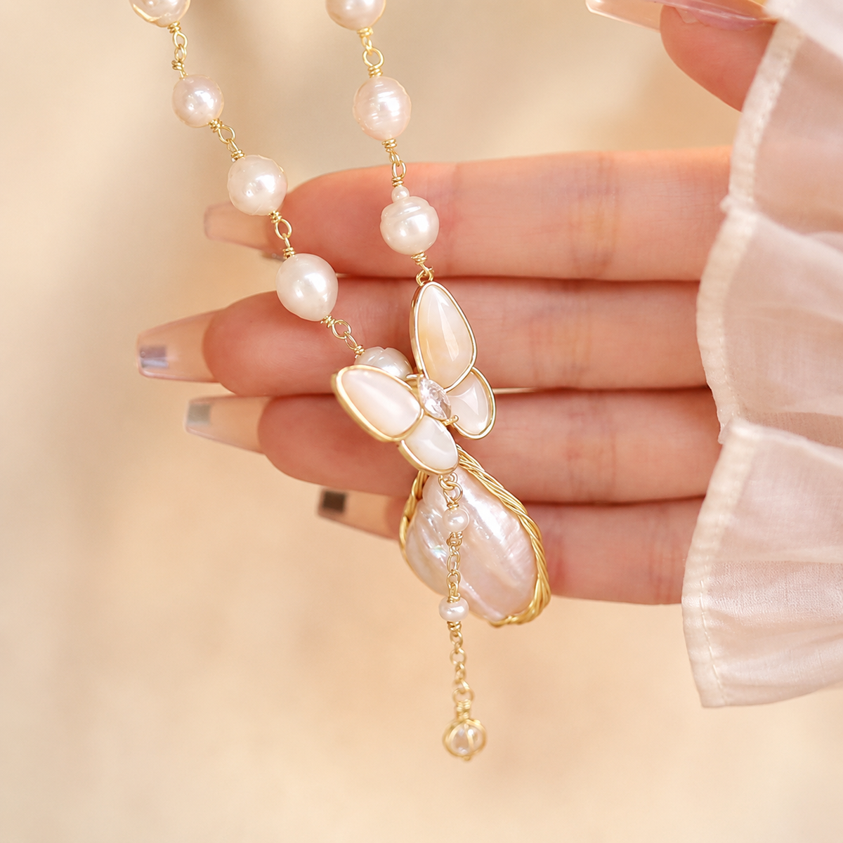 Close-up of a mother-of-pearl butterfly and organic pearl pendant
