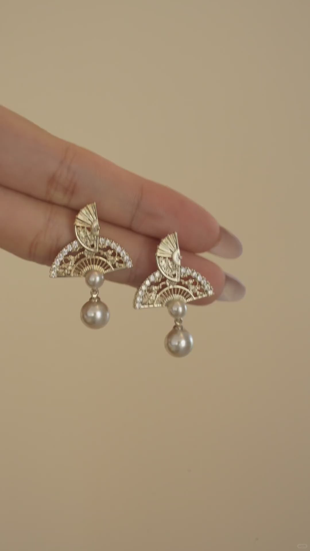 Video view of ornate drop high-lustre freshwater pearl earrings styled for wedding guest looks