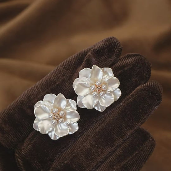 Video view of white flower high-lustre freshwater pearl earrings styled for wedding guest looks