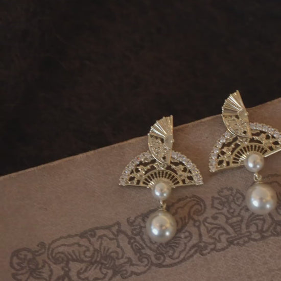 Video view of ornate drop high-lustre freshwater pearl earrings styled for wedding guest looks