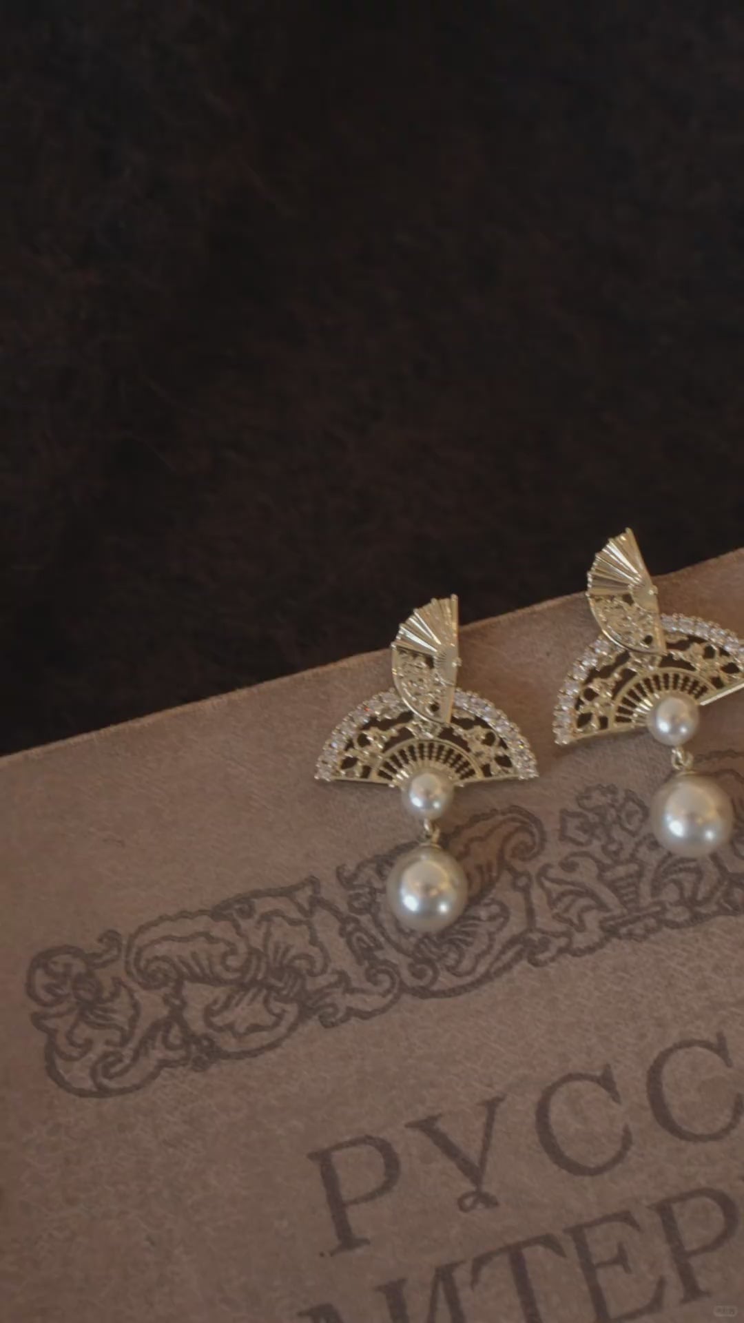 Video view of ornate drop high-lustre freshwater pearl earrings styled for wedding guest looks