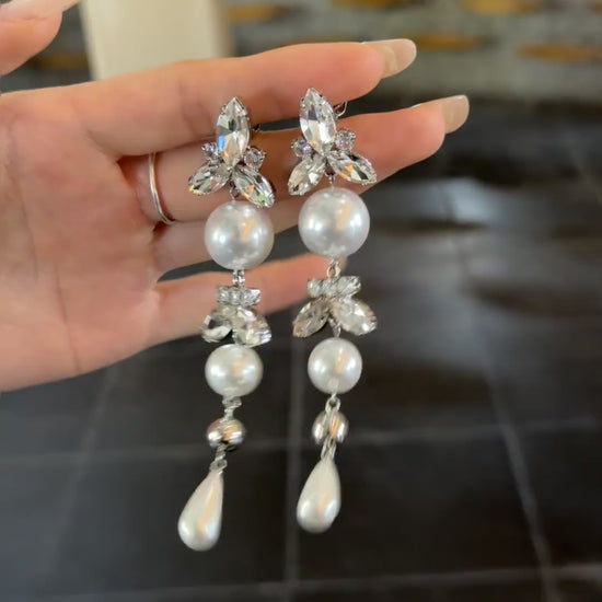 Video view of long pearl drop high-lustre freshwater pearl earrings styled for wedding guest looks