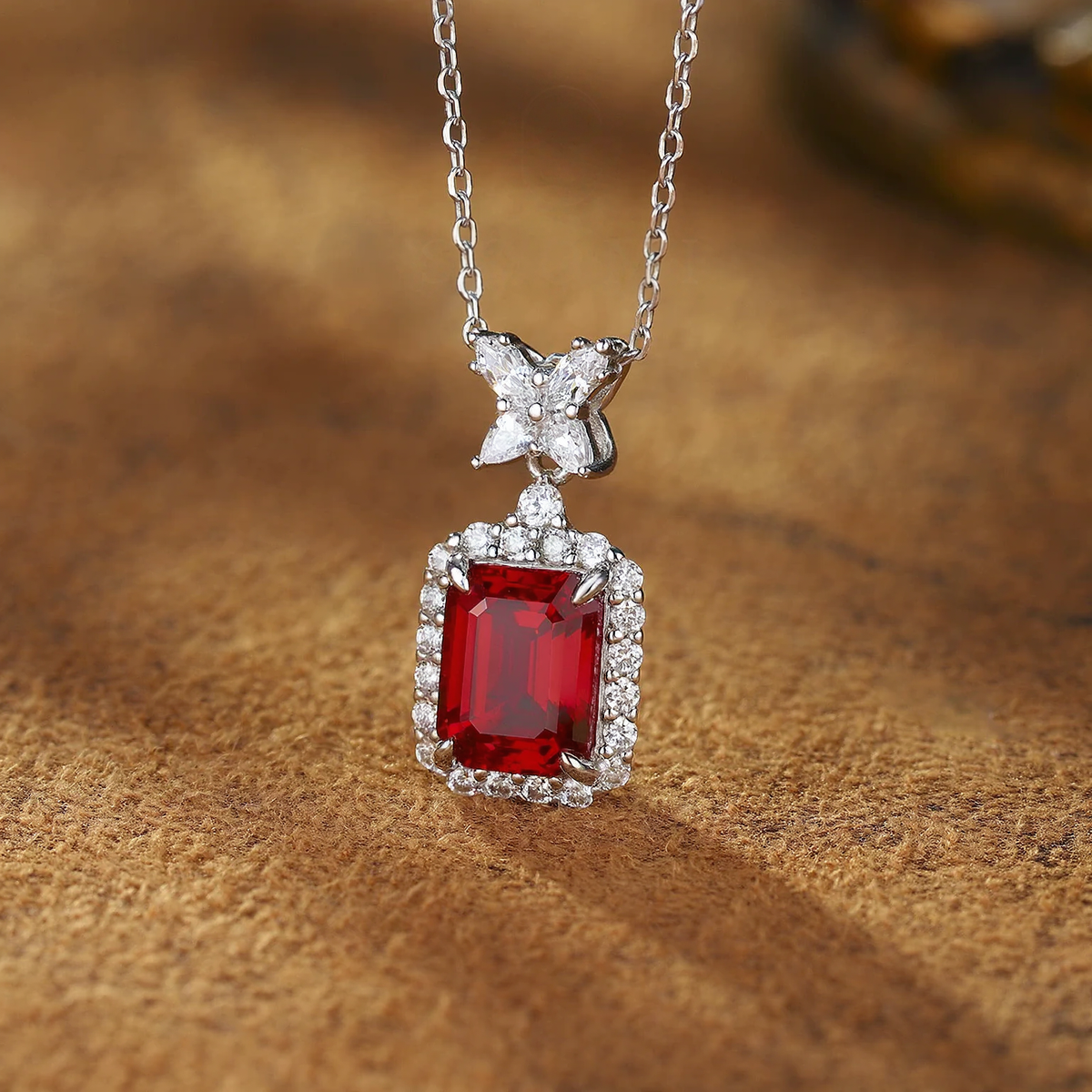 Close-up of lab-grown ruby bow pendant necklace in 16K gold for romantic gifts