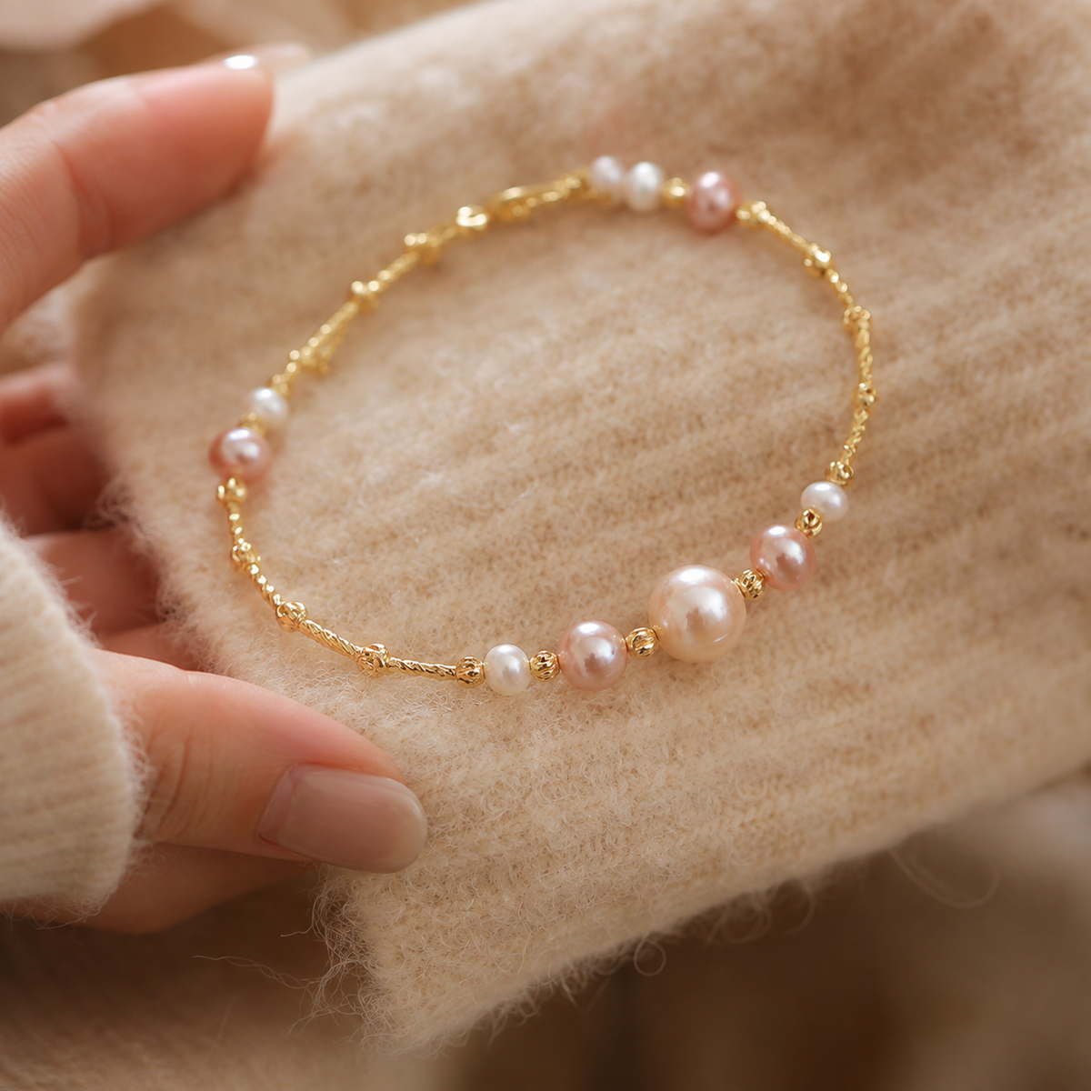 Freshwater pearl station bracelet held in the hand