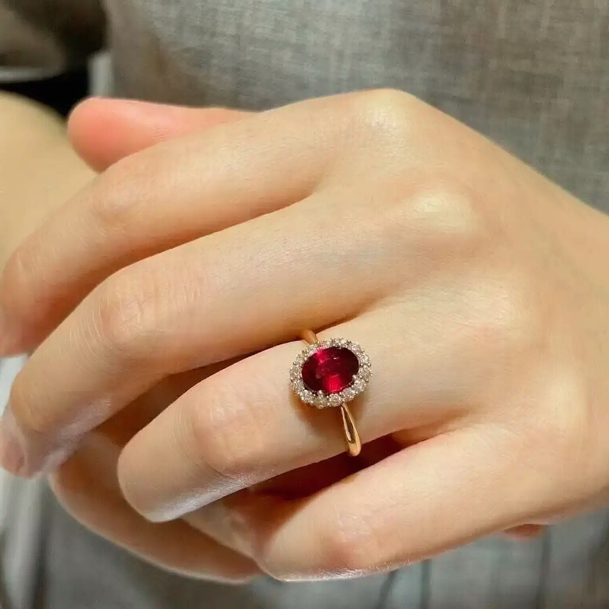 Styled view of oval lab-grown ruby halo ring for proposals