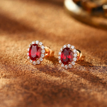 Front view of oval lab-grown ruby halo stud earrings in 14K gold for anniversary gifts