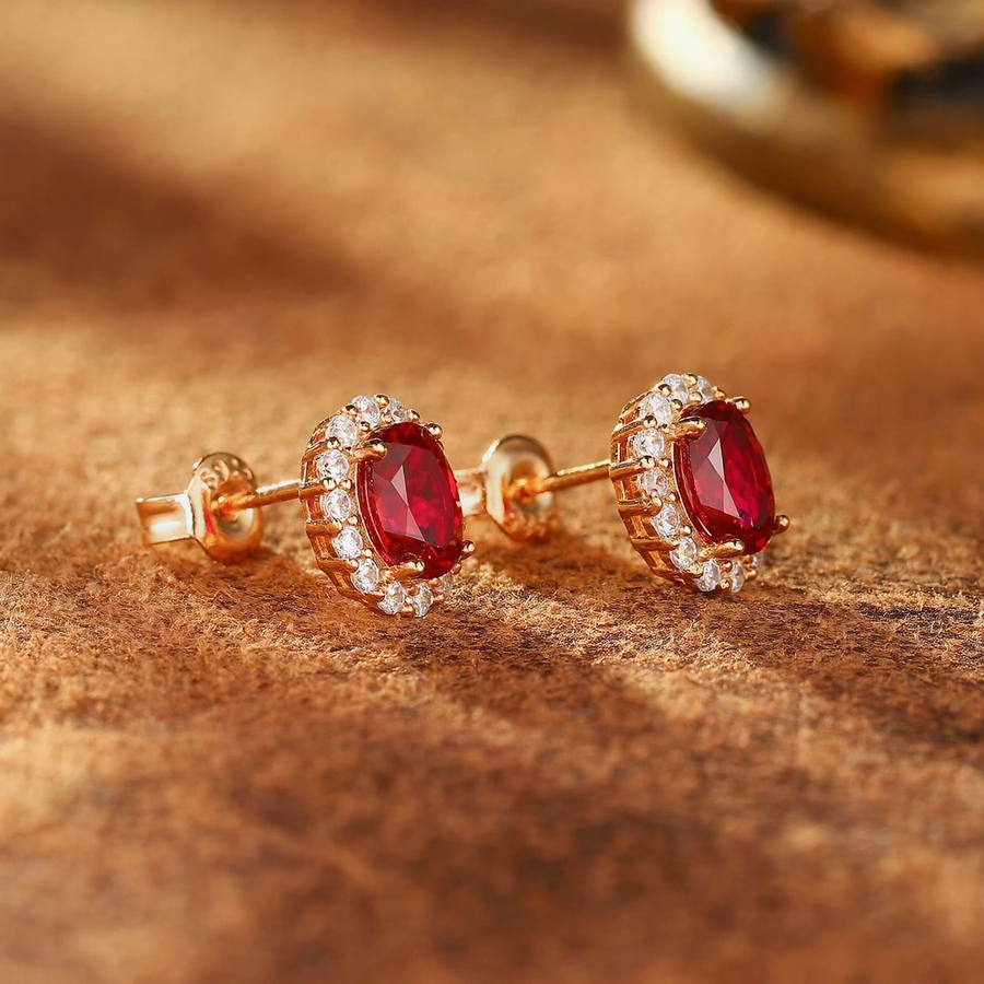Styled view of oval lab-grown ruby halo stud earrings in 14K gold for anniversary gifts