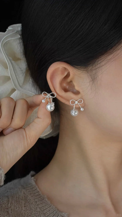 Front view of bow drop high-lustre freshwater pearl earrings for wedding guest looks