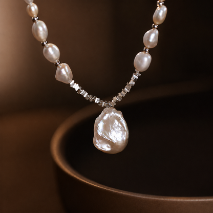 Selene freshwater pearl necklace with a large baroque pendant on a dark background