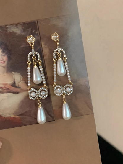 Close-up of filigree drop high-lustre freshwater pearl earrings for wedding guest looks