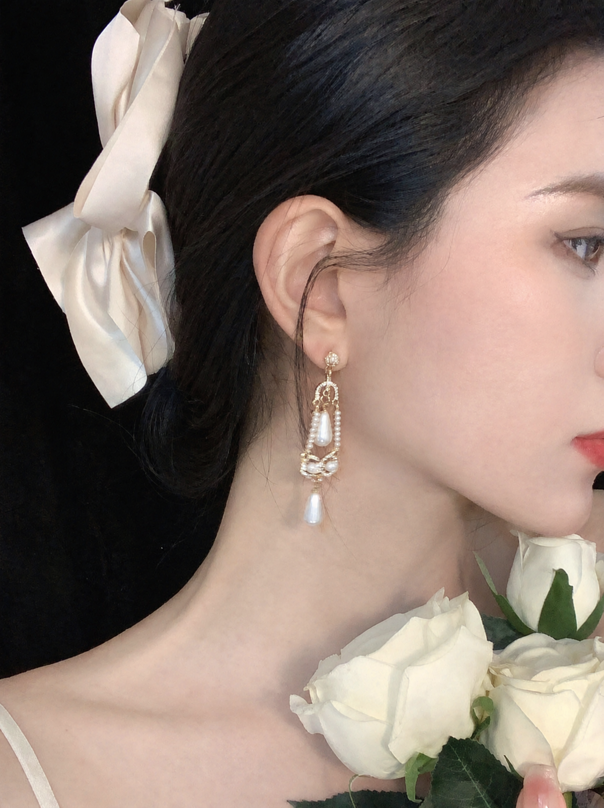 Side view of filigree drop high-lustre freshwater pearl earrings for wedding guest looks