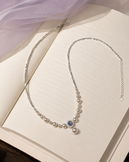 Freshwater pearl and aquamarine pendant necklace styled on an open book