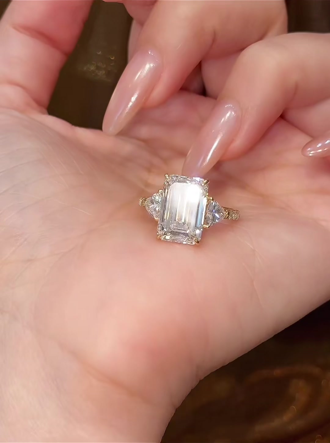 Styled view of lab-grown diamond emerald cut three stone ring for elegant proposals
