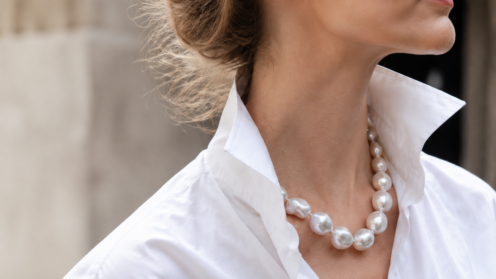 Woman wearing an organic baroque pearl necklace with a white shirt